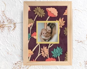 Cornice portafoto vintage in legno con motivo floreale e accogliente ritratto di famiglia.