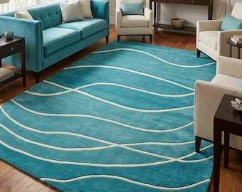 Op de afbeelding: Een rechthoekig vloerkleed met een levendige turquoise achtergrond en een herhalend patroon van vloeiende, golvende witte lijnen die over het gehele oppervlak lopen, wat een dynamisch visueel effect creëert op de vloerbedekking.