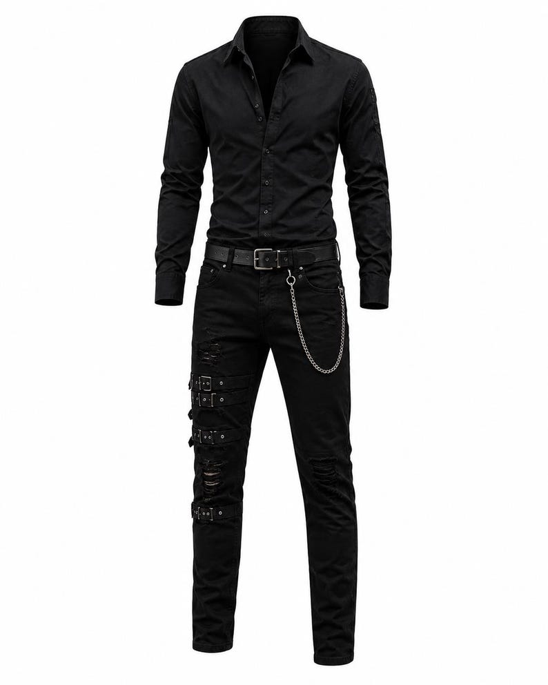 May include: A black long-sleeve button-down shirt paired with black distressed jeans. The jeans feature three horizontal straps with silver buckles on the right leg, a black belt with a silver buckle, and a silver chain attached to the belt loop.