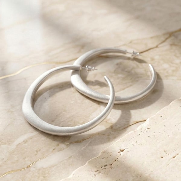 Sculpturale matzilveren oorringen, statement sieraden in Scandinavische stijl