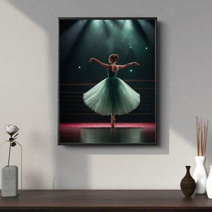 Może przedstawiać: Oprawiony wydruk baletnicy w zielonej tutu na scenie. Tancerka jest na palcach, w świetle reflektorów. Wydruk jest prezentowany na ciemnobrązowej drewnianej powierzchni z dekoracyjnymi wazonami.