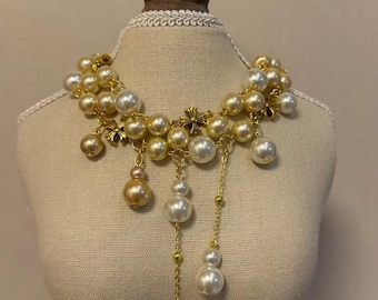 Collier ras-de-cou vintage en fausses perles, orné de fleurs dorées et de pompons pendants.