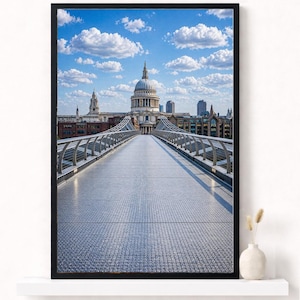 Puede incluir: Impresión enmarcada de la Catedral de San Pablo en Londres, vista desde el Puente del Milenio. La imagen presenta un cielo azul claro con nubes blancas. La estructura de acero del puente conduce a la cúpula de la catedral.