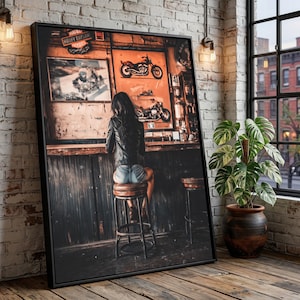 May include: A framed print depicts a woman seated at a bar, with motorcycle art on the wall behind her. The bar setting has a vintage aesthetic, with a brick wall and wooden accents. The artwork features a Harley Davidson logo.