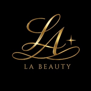 May include: Gold script logo on a black background. The logo features the intertwined letters "LA" with a star icon and the words "LA BEAUTY" below. The design has a luxurious and elegant aesthetic.