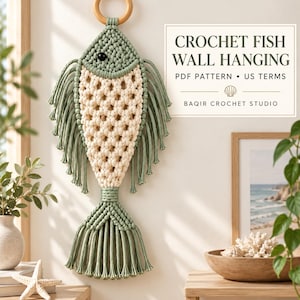 May include: A macrame fish wall hanging featuring sage green and cream cord, a wooden ring at the top, and a black bead eye. Text on the image reads: CROCHET FISH WALL HANGING, PDF PATTERN, US TERMS, BAQIR CROCHET STUDIO, with a small shell icon.