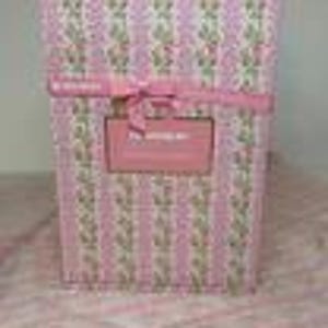 Puede incluir: Una caja de regalo rectangular envuelta en papel rosa con rayas verticales y un estampado floral. Una cinta rosa est&aacute; atada alrededor de la caja y una etiqueta rectangular est&aacute; adherida al frente. El texto en la etiqueta dice "The Wedding Box".
