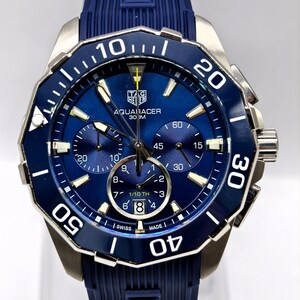Relógio de pulso masculino vintage Tag Heuer Aquaracer com mostrador azul, cronógrafo e bisel giratório.