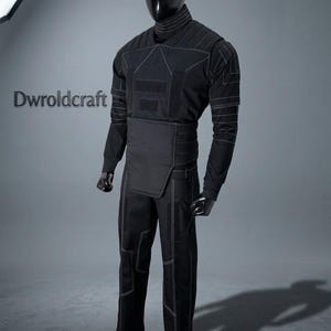 May include: Black tactical suit with white stitching, displayed on a mannequin. The suit includes a long-sleeved top, pants, and a waist protector. The top has a high collar and geometric design. The pants have reinforced knee and thigh panels. The text "Dwroldcraft" is visible.