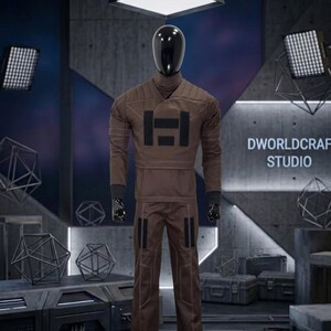 May include: A brown jumpsuit with a high collar and black detailing is displayed on a mannequin. The jumpsuit has a large black graphic on the chest and contrasting stitching. The mannequin is in a studio setting with the text "DWORLDCRAFT STUDIO" visible.