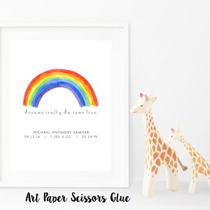 May include: A framed print with a watercolor rainbow illustration. The text "dreams really do come true" is below the rainbow. The print includes the name Michael Anthony Sawyer, birthdate, weight (7 lbs. 6 oz.), and height (20 1/4 in.).