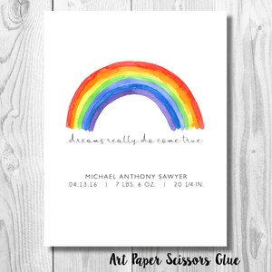 May include: A watercolor print featuring a vibrant rainbow arching over the phrase "dreams really do come true." Below, it includes the name Michael Anthony Sawyer, birthdate, weight (7 lbs 6 oz), and length (20 1/4 in).
