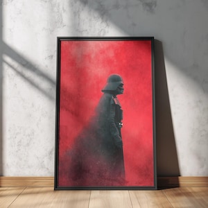 Peut inclure: Une impression d'art murale rectangulaire encadrée représentant le profil latéral d'une silhouette sombre et blindée avec un casque et une cape. La figure se détache sur un fond rouge texturé vibrant qui s'estompe en ombres fumées sombres.