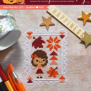 May include: Cross stitch pattern featuring a girl in a red dress with a brown bow in her hair, surrounded by autumn leaves and trees. The pattern is titled "Pen Pals No. 212 - Quilters Fall" and includes the word "Happiness" on a wooden sign.