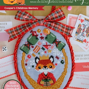 May include: A cross stitch pattern featuring a fox wearing a red and white sweater and a crown, surrounded by Christmas ornaments and presents. The pattern is titled "Cooper's Christmas Memory" and is part of the "2023 Exclusive Jingle Ball Pattern" collection.