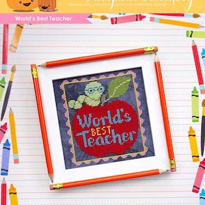 May include: A framed cross stitch pattern with a red apple and the text "World's Best Teacher". The frame is surrounded by pencils and crayons on a lined paper background.