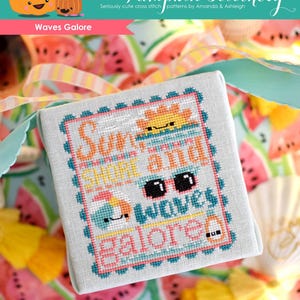 May include: A white cross stitch pattern with a blue, pink, and yellow border. The pattern says "Summer, Sun and Waves Galore".