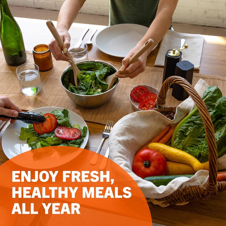 May include: A table setting with fresh vegetables, salad, and a basket filled with produce. The image includes the text "ENJOY FRESH, HEALTHY MEALS ALL YEAR". Wooden salad spoons are used to toss the salad.