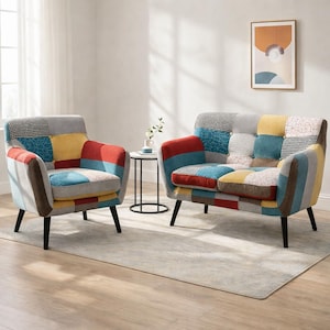 May include: A patchwork armchair and loveseat set with a variety of colorful fabric squares. The furniture has black legs and a neutral gray frame. The set is in a living room setting with a small side table.