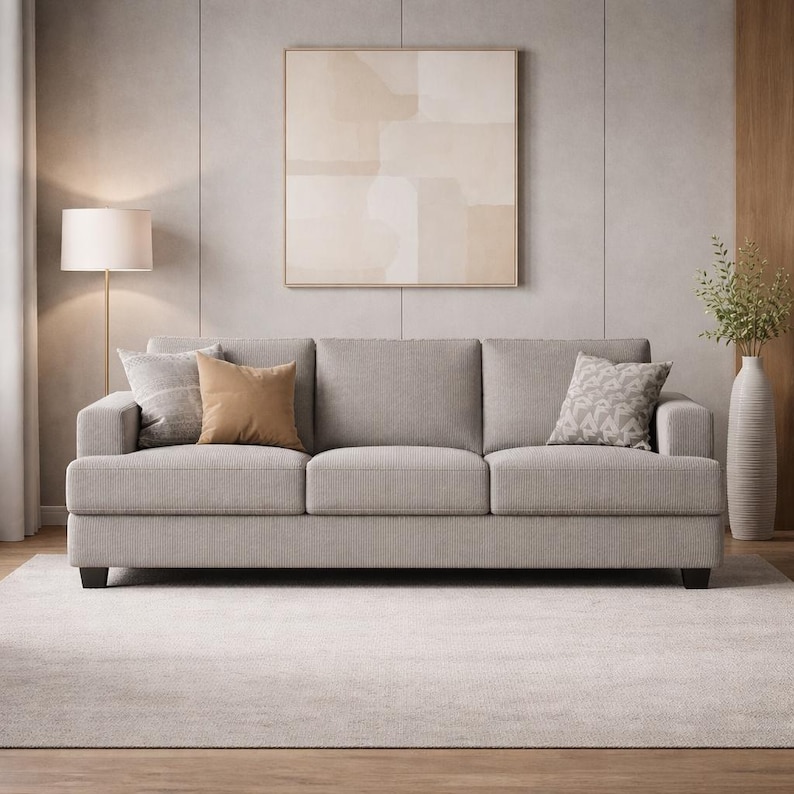 Light gray fabric sofa, neutral modern 3-seat couch, soft upholstery, minimalist Scandinavian living room decor