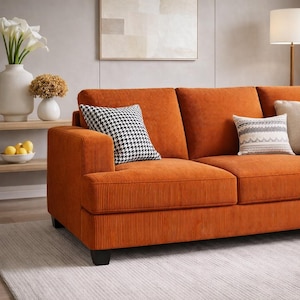 Orange corduroy sofa close up, textured upholstery with accent pillows, modern 3 seater couch styling, cozy home decor