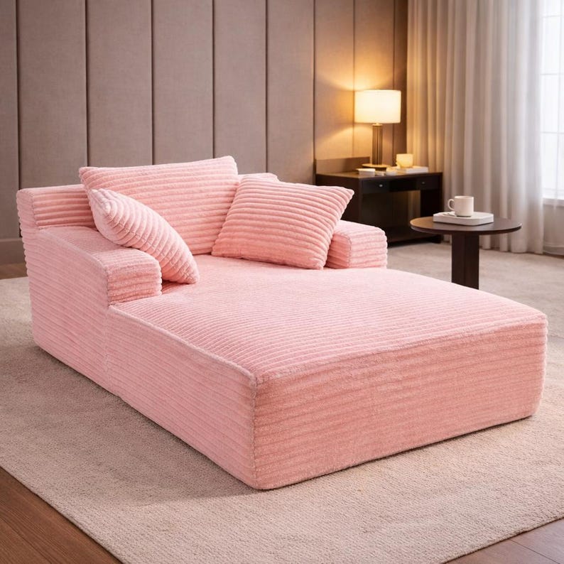 Soft pink corduroy chaise lounge sofa with wide seat and matching pillows, ideal for lounging or reading.