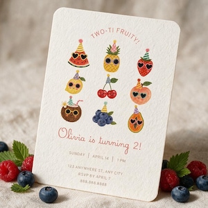 Könnte beinhalten: Eine rechteckige, cremefarbene Einladungskarte mit dem Text TWO-TI FRUITY! und Olivia is turning 2! sowie Illustrationen von neun Früchten mit Partyhüten und herzförmigen Sonnenbrillen, darunter Wassermelone, Ananas, Erdbeere, Zitrone, Kirsche, Pfirsich, Kokosnuss, Blaubeeren und Papaya.