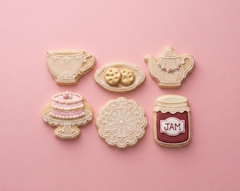 May include: A set of six decorated sugar cookies featuring a cream-colored teacup, a small plate with two round cookies, a cream teapot with pink floral accents, a pink tiered cake on a stand, a white lace doily, and a jar labeled JAM.