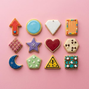 May include: An assortment of decorated cookies in various shapes, including an arrow, circle, diamond, and star, arranged on a pink surface. The cookies feature colorful icing and intricate designs, perfect for a sweet treat or gift.