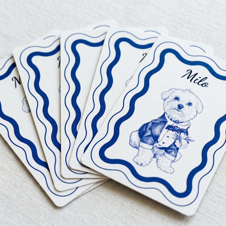 A set of custom playing cards featuring a blue line-art illustration of a dog in a suit with a wavy blue border and the name 'Milo'.