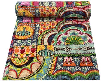 Op de afbeelding: Een kleurrijke patchworkquilt met een gerolde rand. De quilt heeft verschillende patronen, waaronder aardbeien, uien en bloemmotieven. Het kleurenpalet omvat roze, geel, blauw en groen. De quilt is gemaakt van stof en heeft een gestikt ontwerp.