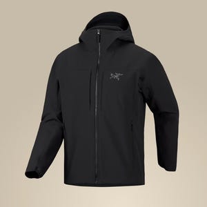 Puede incluir: Una chaqueta negra con capucha que presenta una cremallera frontal completa, dos grandes bolsillos verticales en el pecho y un pequeño logotipo gris en la parte superior izquierda. La prenda incluye mangas largas y una capucha estructurada.