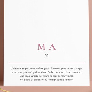 May include: A white rectangular card with the word "MA" in a mauve color, along with Japanese characters. Below the text is a line of text in French. Two green and orange leaves are on the surface.