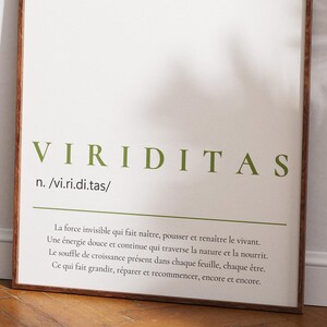 Peut inclure: Une affiche encadrée avec le mot "VIRIDITAS" en lettres vertes. L'impression comprend une définition et une citation en français. Le cadre est de couleur marron foncé, et l'affiche est appuyée contre un mur blanc.