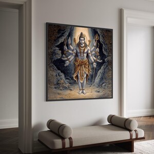 May include: A framed print showing a multi-armed deity with a calm expression. The figure wears jewellery and a golden cloth. The background depicts a cave with a light source highlighting the central figure. The artwork is displayed on a white wall, adding a touch of serenity.