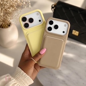 May include: Two silicone smartphone cases with integrated card slots on the back. One case is light yellow and the other is beige. Both feature a raised camera cutout with three circular lens openings and a small circular flash opening.