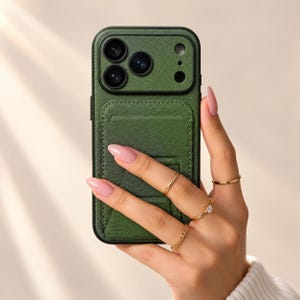 May include: A dark green textured phone case with a built-in card holder and integrated stand. The case features a raised camera cutout section with three circular lens openings and a flash aperture, providing a secure fit for the device.