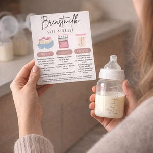 May include: A clear baby bottle filled with breast milk, held next to a card with text about breast milk storage. The card has illustrations of storage methods and text that reads "Breastmilk Safe Storage".