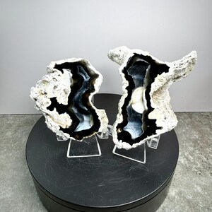 May include: Two geode halves with a black and white interior and a rough, textured exterior. The geodes are displayed on clear stands, set against a neutral background. The base is black, and the text "Set 3" is visible.