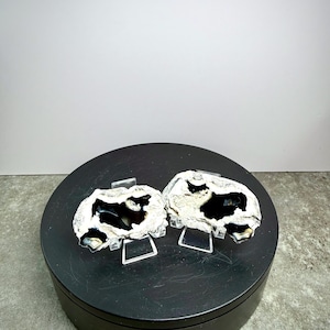 May include: Two geode slices with black and white patterns, displayed on clear stands. The geodes are set on a black, circular platform. The text "Set 10" is visible at the bottom of the image.