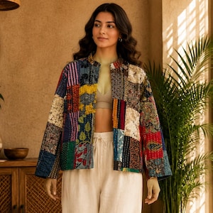 Peut inclure: Une veste à manches longues en patchwork composée de divers carrés de tissus colorés et à motifs dans des tons de bleu, rouge, jaune et vert, associée à un pantalon large taille haute crème et un haut court de couleur neutre.