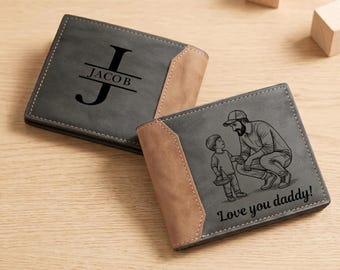 May include: Two bi-fold wallets featuring a grey and tan color scheme with visible stitching. One wallet displays a large letter J with the name JACOB engraved. The other wallet features an engraved illustration of a child and adult with the text Love you daddy!