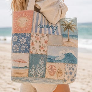 May include: A patchwork tote bag featuring a variety of coastal and floral prints, including a smiling sun, a palm tree, a crashing wave, seashells, and a beach umbrella. The name avery is embroidered in blue script across a light blue striped panel.