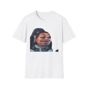 Puede incluir: Camiseta blanca con un meme de una persona con la cara distorsionada, sentada en una silla de juego negra y azul. La imagen está centrada en la parte delantera de la camiseta, mostrando el diseño humorístico.