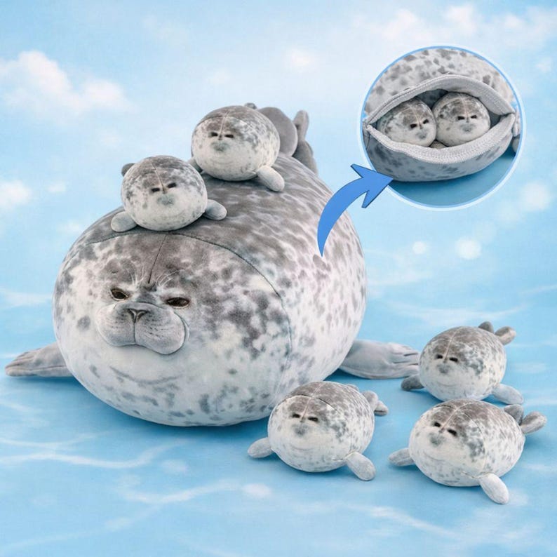 Pode incluir: Um brinquedo de pel&uacute;cia de foca cinzenta com manchas mais escuras e v&aacute;rias pel&uacute;cias de foca menores. A foca principal tem um corpo grande, e as focas menores t&ecirc;m um design semelhante. Uma das focas tem um bolso com duas focas menores dentro. O fundo &eacute; azul claro.