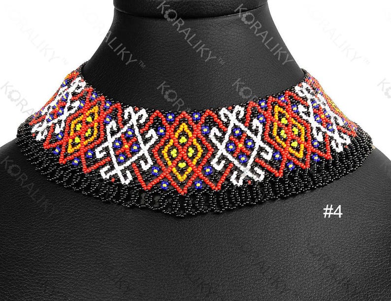 May include: A colourful beaded choker necklace with a black base and patterns in red, yellow, white, and blue. The necklace is displayed on a black mannequin head. The number "4" is visible.