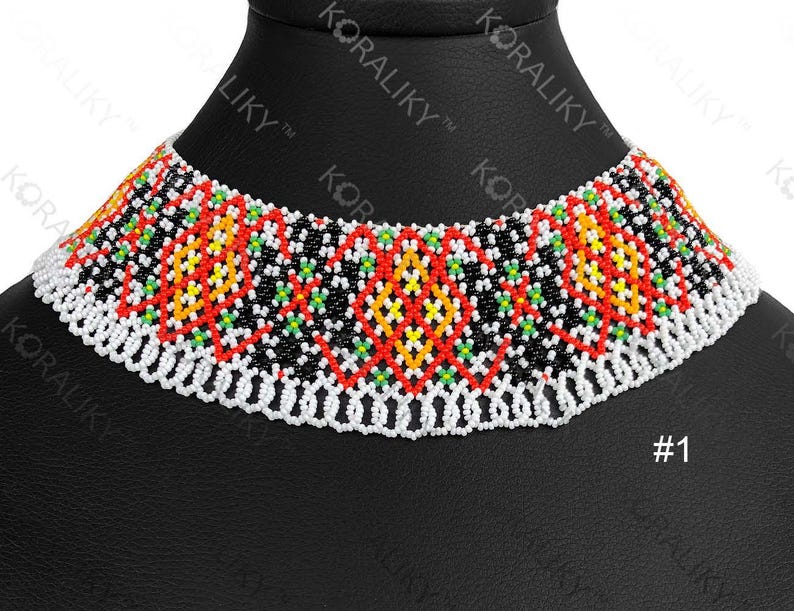 May include: A colourful beaded choker necklace with a geometric pattern. The necklace has a white beaded base with a pattern of red, yellow, green, and black beads. The necklace is displayed on a black mannequin.