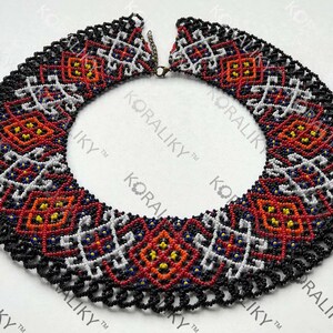 May include: A colourful beaded necklace featuring a geometric design in red, white, black, and yellow. The necklace has a scalloped edge and a clasp. The text "#4" is visible on the right side of the image.