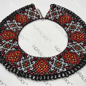 May include: A collar necklace crafted from beads, featuring a black background and detailed patterns in red, white, yellow, and green. The design incorporates geometric and floral motifs. The text "#3" is visible on the bottom right.