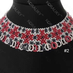 May include: A red, white, and black beaded necklace with a geometric pattern. The necklace is on a black display stand. #2